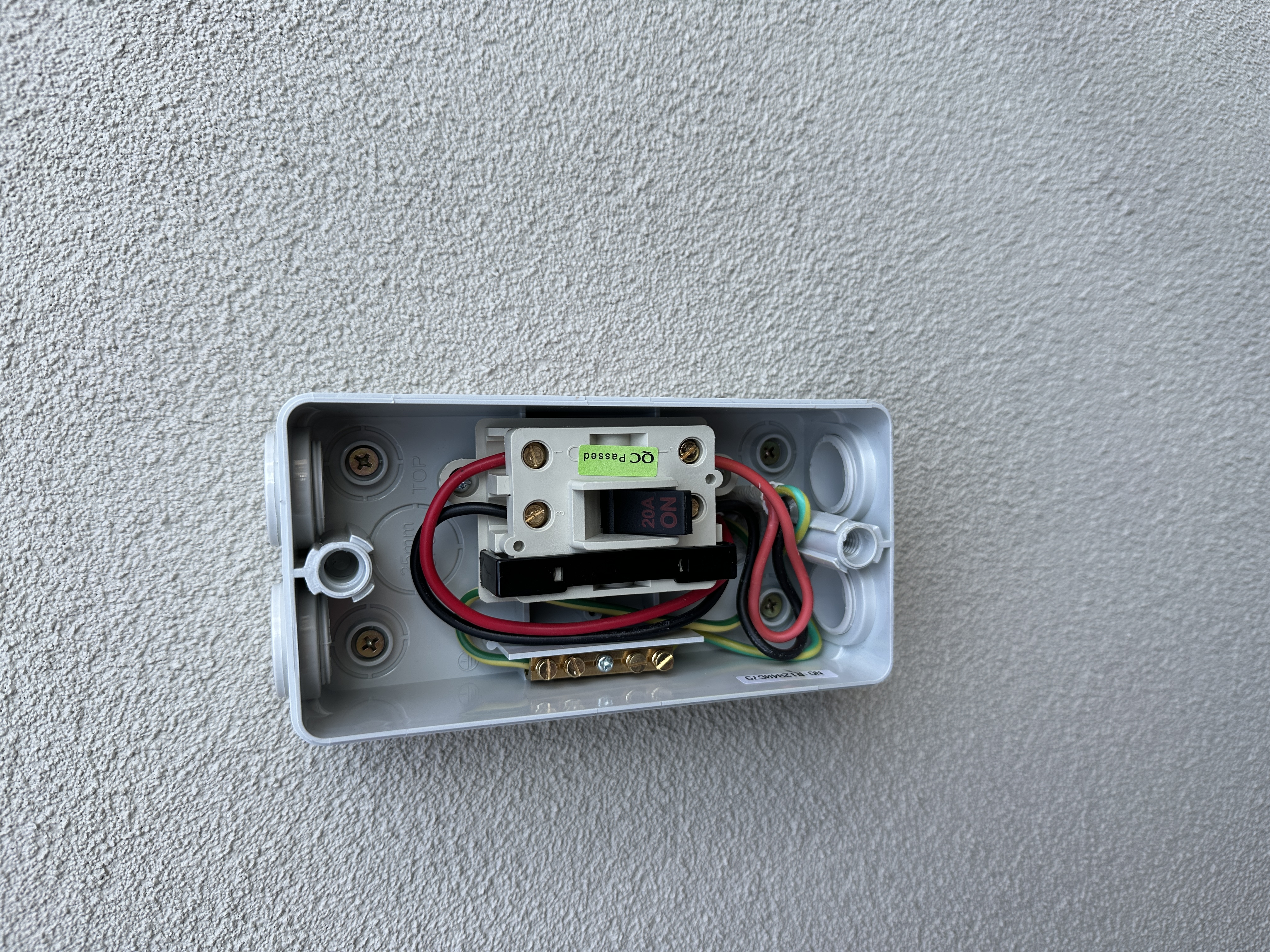 Outdoor circuit breaker installation on rendered wall